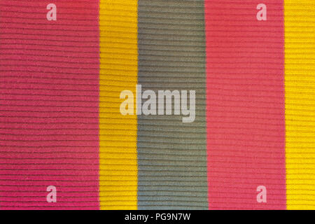 Tuch Textilien in einer farbigen Streifen von Rot, Gelb und Grau für den Einsatz als Hintergrund. Stockfoto