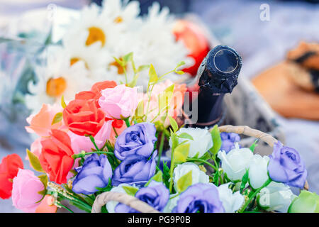 Flasche Champagner und Blumenstrauß aus Rosen, Nahaufnahme Stockfoto