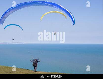 Paragliding Mann weg vom Rand der Klippe. Stockfoto