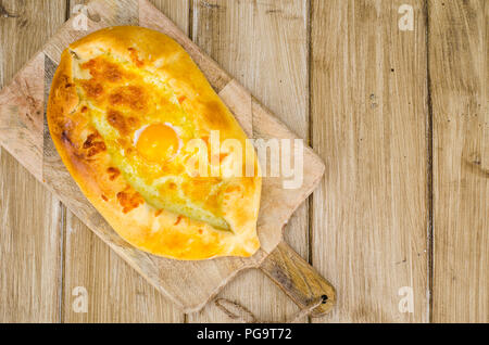 Hot khachapuri mit Käse und Ei auf Holzbrett. Studio Foto Stockfoto