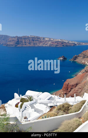 Blick auf den Kraterrand auf Santorini mit einer kleinen Kapelle auf einem Felsen im Vordergrund. Stockfoto