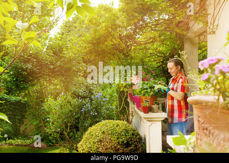 Mädchen schneiden von Pflanzen mit hochentaster im Garten Stockfoto