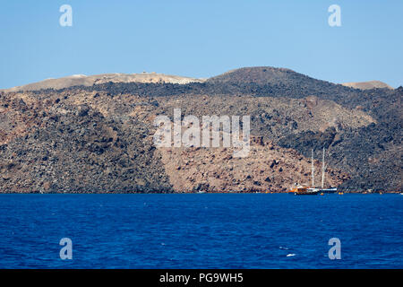 Lava Hügel und Boote in Nea Kameni. Santorini, Griechenland. Stockfoto