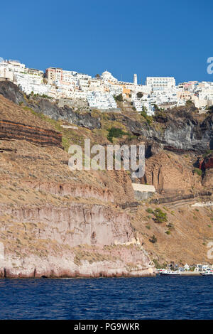 Blick von einem Boot auf die kraterwand von Santorini, Griechenland mit dem Zentrum der Hauptstadt Fira auf dem Kraterrand. Stockfoto