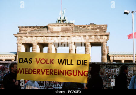 Die westdeutschen Bürger Anzeige ein Banner, wie Sie eine Mahnwache für den Abriss der Berliner Mauer am Brandenburger Tor. Ein Teil der Mauer wurde bereits am Potsdamer Platz abgerissen. Stockfoto