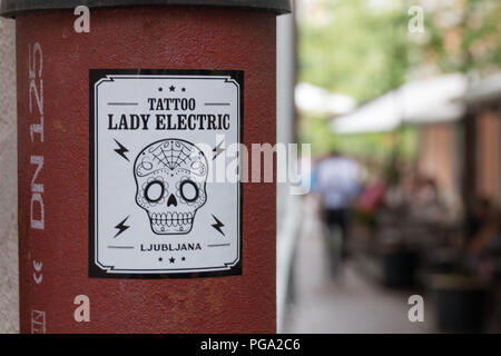 Ljubljana, Slowenien - 23. Juli 2018: Ansicht einer eisernen Säule mit einer Werbung Aufkleber für ein Tattoo Studio namens Lady Electric in Lubljana, Slovenien Stockfoto