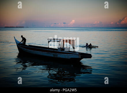 Ein Fischer vor der Küste von Mabul Island, Borneo, Malaysia, bei Sonnenuntergang. Stockfoto