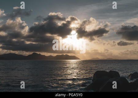 Sonnenuntergang über Praslin von La Digue gesehen. Stockfoto