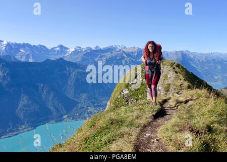 Weibliche Wanderer mit Blick auf den Brienzersee in den Schweizer Bergen - Hardergrat Trail Finisher Stockfoto