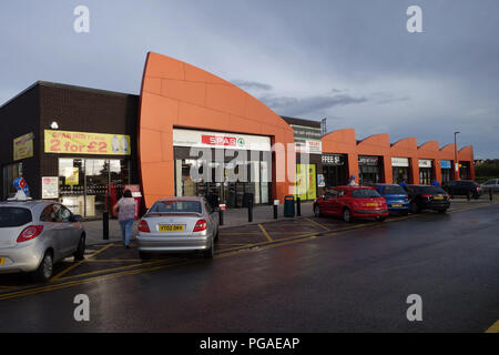 Die verschiedenen bunten Geschäften, Imbissbuden und Restaurants im Onyx Retail Park, Wath auf Dearne, Yorkshire in einem Sturm Cloud Nachthimmel Stockfoto