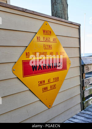 Ocean Beach Warnschild, dass keine Rettungsschwimmer ist und auf eigene Gefahr zu schwimmen, wenn keine Flaggen in Destin Florida, USA fliegen. Stockfoto