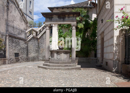 Alter Brunnen auf der Piazza Cesare Augusto Tallone auf dem Weg der Stille, der Isola San Giulio Ortasee, Italien. Stockfoto