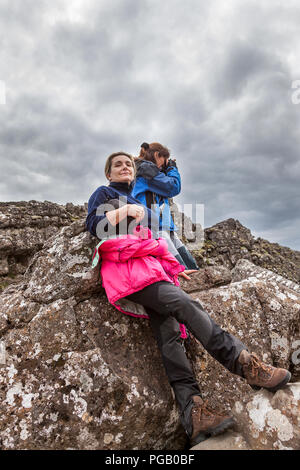 Fotograf mit seiner Assistentin nimmt ein Bild auf dem Lavagestein in den Nationalpark Pingvellir Island Stockfoto