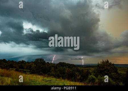 Blitze bei einem sommerlichen Abend Gewitter über einen mittleren Westen Feld. Stockfoto