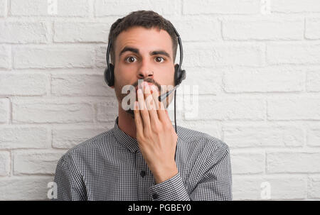 Junge erwachsene Menschen über die Mauer, die als Betreiber decken den Mund mit der Hand mit Schande für den Fehler, den Ausdruck von Angst erschüttert, die in der Stille Angst, Protokollführer Stockfoto