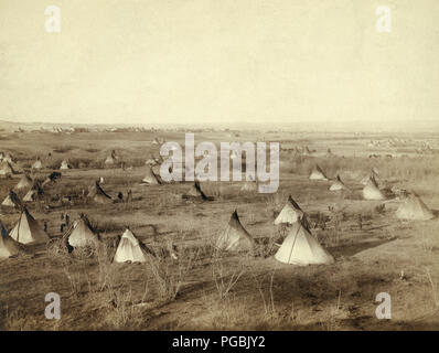 Aus der Vogelperspektive a Lakota Camp (mehrere Tipis und Wagen im großen Feld) - voraussichtlich am oder in der Nähe von Pine Ridge Reservat. Stockfoto