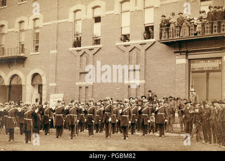 Gruppe von uniformierten Männern vor einem großen Backsteingebäude posieren. Stockfoto