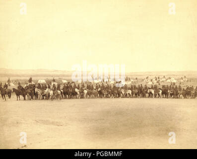 Lange Reihe von Militärs und Lakota Pfadfinder auf dem Pferd vor tipi Camp - vermutlich auf oder in der Nähe von Pine Ridge Reservat. Stockfoto