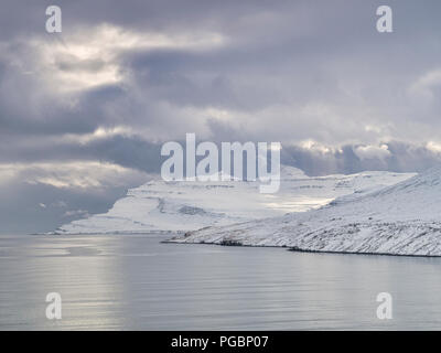 Snowy Mountains in Islands östlichen Fjorden unter einem Moody Himmel. Stockfoto