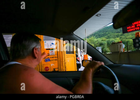 Ostrovica, Kroatien - August 1th, 2018: Ein Mann wird von der Autobahn Karte auf der Autobahn Mautstelle Ostrovica in Ostrovica, Kroatien. Stockfoto