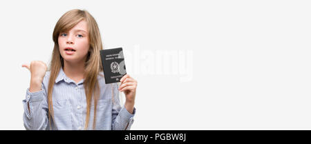 Junge blonde toddler Holding italienischer Pass zeigt mit Finger- und oben mit glücklichen Gesicht lächelnd Stockfoto