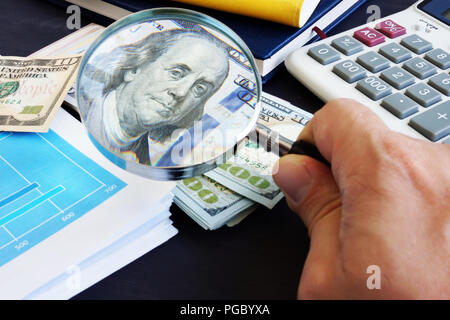 Mann, durch die Lupe auf einen Dollar Banknote. Rechnungsprüfung und Finanzkontrolle. Stockfoto