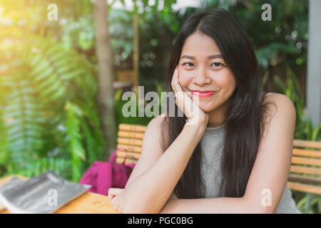 Schöne asiatische Thai Lächeln cute Teen schwarzes Haar im Garten Haltung entspannen Stockfoto