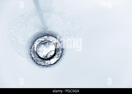Wasser spülen Löcher in Badezimmer Waschbecken Waschbecken Stockfoto