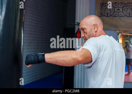 Ein Mann Züge am MMA Tasche die Beulen aus zu arbeiten Stockfoto