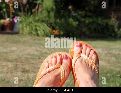 Sommer Füße entspannen in cool orange Flip Flops Stockfoto