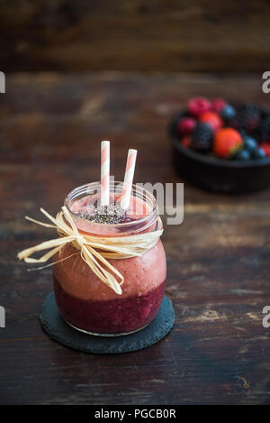 Frische Beeren Obst Smoothie mit Chia Samen auf rustikalen hölzernen Hintergrund Stockfoto