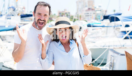 Paar mittleren Alters in der Marina sehr glücklich und aufgeregt, Sieger Ausdruck feiern Sieg schreien mit einem großen Lächeln und erhobenen Händen Stockfoto
