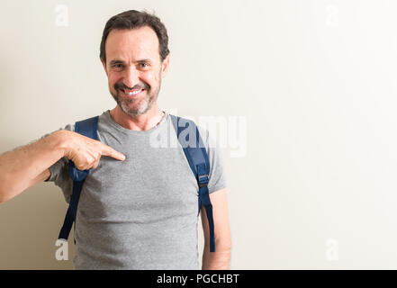 Älterer Mann mit Rucksack mit Überraschung Gesicht zeigenden Finger zu sich selbst Stockfoto