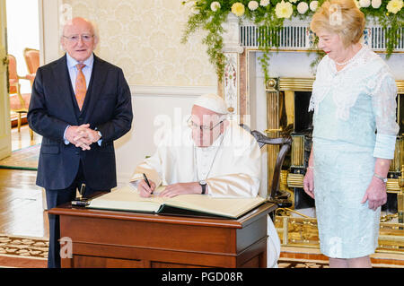 Dublin, Irland. 25/08/2018 - Papst Franziskus zeichen Buch des Besuchers als er nach Irland begrüßt wird durch die irische Präsidentin, Michael D. Higgins, und seine Frau Sabina, bei den Aras eine Uachtarain (Präsident des offiziellen Wohnsitz). Stockfoto