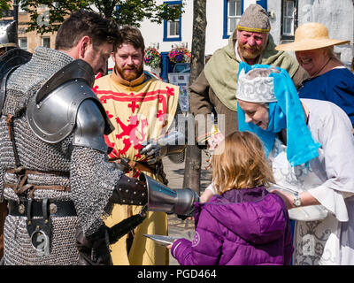 Haddington, Schottland, Großbritannien. 25. August 2018. Haddington 700 Feiern mittelalterliche Big Day, der Tag des Mittelalters ist der Höhepunkt von Haddington 700 Veranstaltungen, die im Jahr 2018 für die Gewährung einer Charta von Robert the Bruce in die Stadt im Jahre 1318 feiern, der Bestätigung Haddington das Recht, einen Markt zu halten und den Zoll zu sammeln. Veranstaltungen in der Stadt gehören die mittelalterliche Spiele Kinder und eine Parade. Männer gekleidet als mittelalterliche Ritter und ein Paar in mittelalterlichen Kostüm Stockfoto