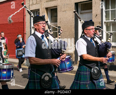 Haddington, Schottland, Großbritannien. 25. August 2018. Haddington 700 Feiern mittelalterliche Big Day, der Tag des Mittelalters ist der Höhepunkt von Haddington 700 Veranstaltungen, die im Jahr 2018 für die Gewährung einer Charta von Robert the Bruce in die Stadt im Jahre 1318 feiern, der Bestätigung Haddington das Recht, einen Markt zu halten und den Zoll zu sammeln. Veranstaltungen in den Markt der Stadt gehören eine Parade. Haddington Pipe Band gekleidet in Kilts führen die Parade durch die Straßen der Stadt Stockfoto