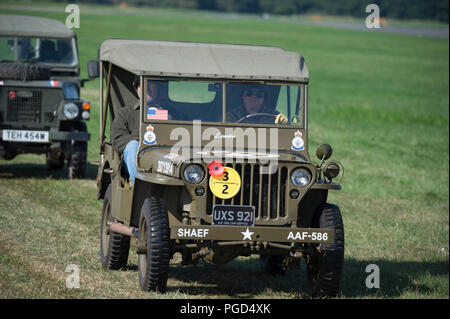 Dunsfold Park, Surrey, Großbritannien. 25 August, 2018. Wochenende iconic Aviation und Autofahren in Dunsfold mit Flugvorführungen und modern, classic & vintage Supercars. Wetter Änderungen können bändigen kann Fliegen Aktivitäten am Sonntag, den 26. August als schwerer Regen prognostiziert wird. Das militärfahrzeug Parade verfügt über eine Vielzahl von Lkw, Rüstung und Dienstwagen aus den 1940er Jahren. Credit: Malcolm Park/Alamy Leben Nachrichten. Stockfoto