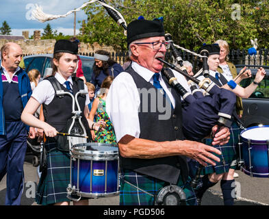 Haddington, Schottland, Großbritannien. 25. August 2018. Haddington 700 Feiern mittelalterliche Big Day, der Tag des Mittelalters ist der Höhepunkt von Haddington 700 Veranstaltungen, die im Jahr 2018 für die Gewährung einer Charta von Robert the Bruce in die Stadt im Jahre 1318 feiern, der Bestätigung Haddington das Recht, einen Markt zu halten und den Zoll zu sammeln. Veranstaltungen in den Markt der Stadt gehören eine Parade. Haddington Pipe Band gekleidet in Kilts führen die Parade durch die Straßen der Stadt Stockfoto