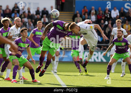 Swansea, Großbritannien. 25 Aug, 2018. Nur die redaktionelle Nutzung, eine Lizenz für die gewerbliche Nutzung erforderlich. Keine Verwendung in Wetten, Spiele oder einer einzelnen Verein/Liga/player Publikationen. Jay Fulton von Swansea City versucht, ein erntevorsatz am Ziel als Bristol City Marlon Pack Bausteine mit seinem Kopf. EFL Skybet Meisterschaft übereinstimmen, Swansea City v Bristol City an der Liberty Stadium in Swansea, South Wales am Samstag, den 25. August 2018. Dieses Bild dürfen nur für redaktionelle Zwecke verwendet werden. Nur die redaktionelle Nutzung, eine Lizenz für die gewerbliche Nutzung erforderlich. Keine Verwendung in Wetten, Spiele oder einer einzelnen Verein/Liga/player Publikationen. pic von Andrew Obstgarten/und Stockfoto