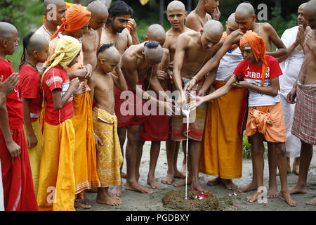 Kathmandu, Nepal. 26 Aug, 2018. Nepalesische jungen Hindu Priester führen Rituale während Janai Purnima oder Heiligen Thread Festival in Pashupathinath Tempel in Kathmandu, Nepal am Sonntag, den 26. August 2018. Es wird angenommen, dass das Binden der Heiligen thread rids Hautkrankheiten. Credit: Skanda Gautam/ZUMA Draht/Alamy leben Nachrichten Stockfoto