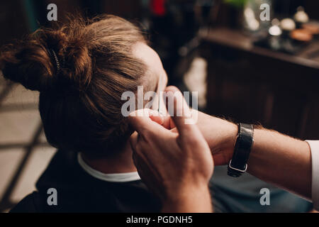 Barbershop mit Interieur aus Holz. Bärtige Modell Mann und Friseur. Stockfoto