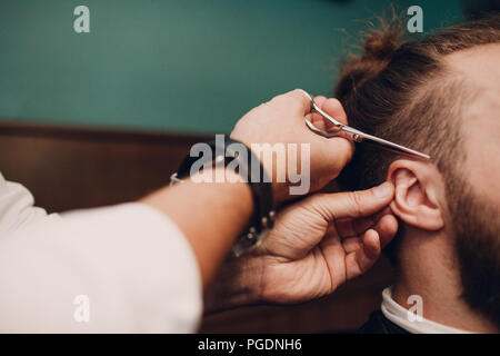 Barbershop mit Interieur aus Holz. Bärtige Modell Mann und Friseur. Stockfoto