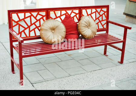 Red asiatisch inspirierte Sitzbank mit Kissen Stockfoto