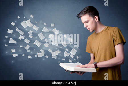 Lässige junge Mann mit Buch mit Seiten fliegen aus Es Stockfoto