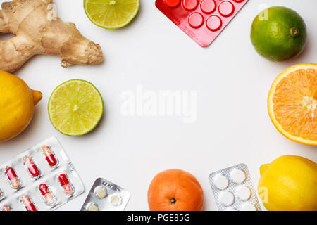 Foto Blister mit Tabletten, Ingwer, Zitrone, Limette, orange auf leeren weißen Raum. Stockfoto