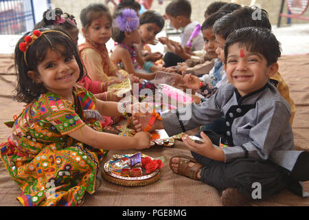 Ajmer, Indien. 25 Aug, 2018. Ein indisch-hinduistischen Mädchen Bindungen rakhis, oder heilige Gewinde, am Handgelenk ihres Bruders als symbolische Geste während der "Raksha Bandhan' Festival in Ajmer, Rajasthan, Indien, 25. August 2018. "Raksha Bandhan' feiert das Verhältnis zwischen den Brüdern und Schwestern. Foto von shaukat ahmed Credit: shaukat Ahmed/Pacific Press/Alamy leben Nachrichten Stockfoto