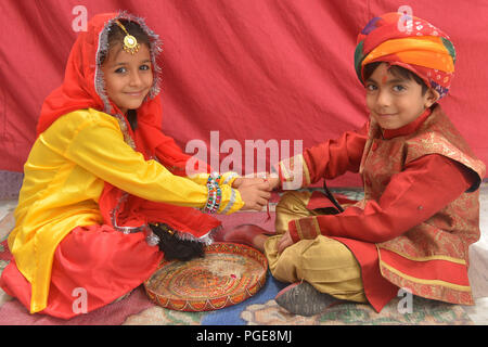 Ajmer, Indien. 25 Aug, 2018. Ein indisch-hinduistischen Mädchen Bindungen rakhis, oder heilige Gewinde, am Handgelenk ihres Bruders als symbolische Geste während der "Raksha Bandhan' Festival in Ajmer, Rajasthan, Indien, 25. August 2018. "Raksha Bandhan' feiert das Verhältnis zwischen den Brüdern und Schwestern. Foto von shaukat ahmed Credit: shaukat Ahmed/Pacific Press/Alamy leben Nachrichten Stockfoto
