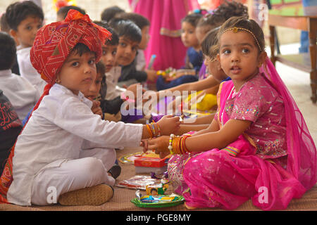 Ajmer, Indien. 25 Aug, 2018. Ein indisch-hinduistischen Mädchen Bindungen rakhis, oder heilige Gewinde, am Handgelenk ihres Bruders als symbolische Geste während der "Raksha Bandhan' Festival in Ajmer, Rajasthan, Indien, 25. August 2018. "Raksha Bandhan' feiert das Verhältnis zwischen den Brüdern und Schwestern. Foto von shaukat ahmed Credit: shaukat Ahmed/Pacific Press/Alamy leben Nachrichten Stockfoto