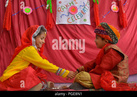 Ajmer, Indien. 25 Aug, 2018. Ein indisch-hinduistischen Mädchen Bindungen rakhis, oder heilige Gewinde, am Handgelenk ihres Bruders als symbolische Geste während der "Raksha Bandhan' Festival in Ajmer, Rajasthan, Indien, 25. August 2018. "Raksha Bandhan' feiert das Verhältnis zwischen den Brüdern und Schwestern. Foto von shaukat ahmed Credit: shaukat Ahmed/Pacific Press/Alamy leben Nachrichten Stockfoto