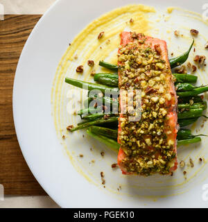 Honig und Dijon Senf gebackenen Lachs mit Pekannüssen und Dill, serviert mit grünen Bohnen auf einem weissen Teller, Schuß-legen Stockfoto